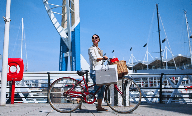 woman smiling next to bike with shopping bags
